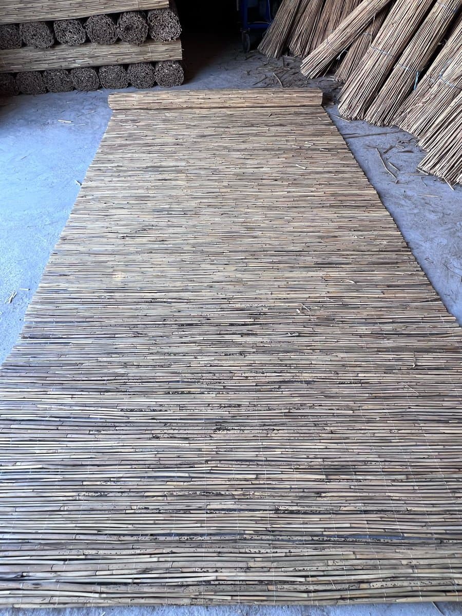 Reed mat rolls stacked in facility